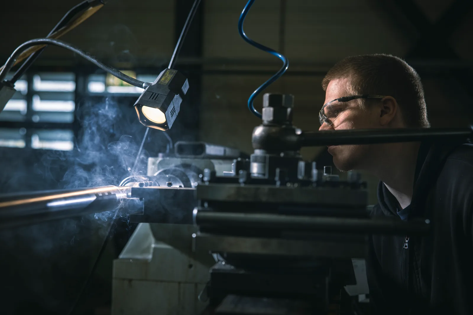 Fachkraft mit Schutzbrille an einer Drehmaschine