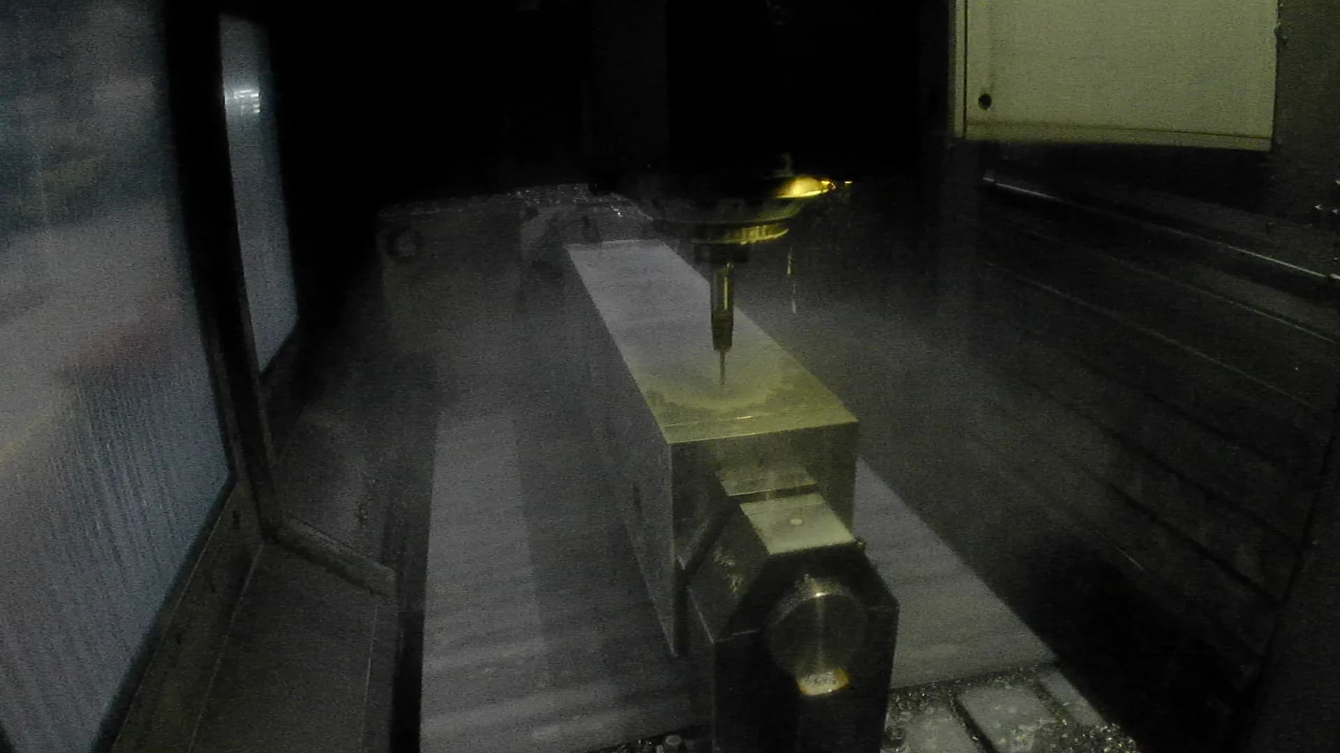 Gereedschap bewerkt een opgespannen metalen werkstuk met koelmiddel