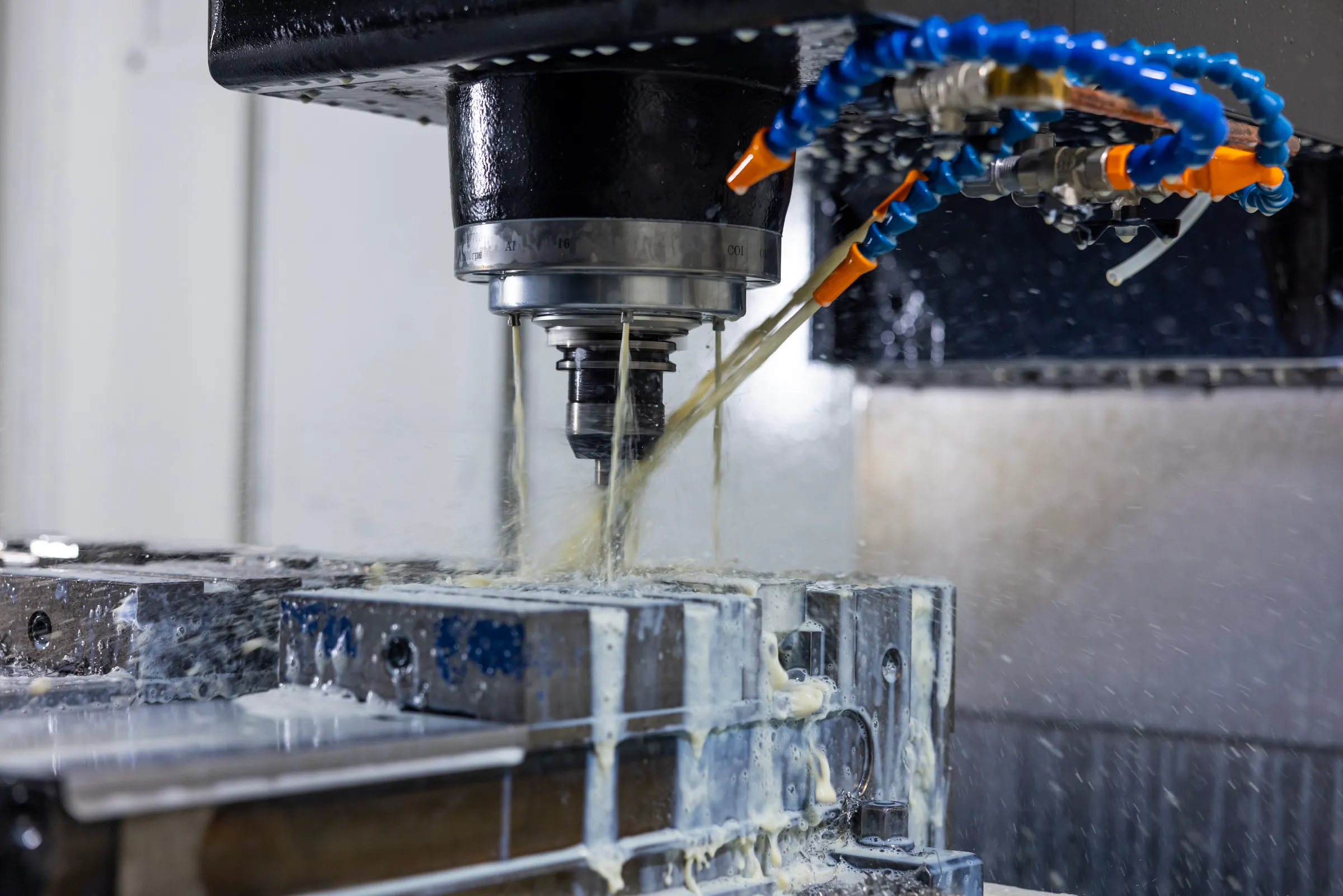 Freesgereedschap bewerkt een opgespannen metalen werkstuk met koelmiddel