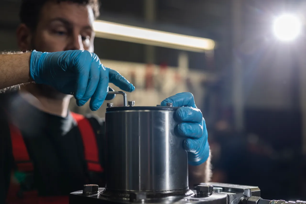Medewerker bevestigt een deksel op een mechanische samenstelling