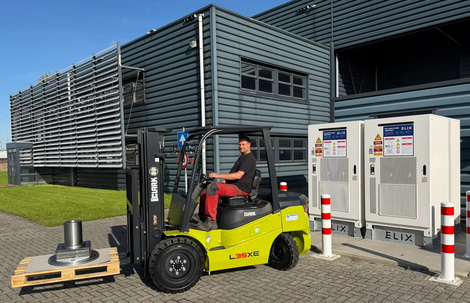 Electric Clark L35XE forklift with its driver beside the battery storage system at Douna’s Hidalgoweg premises.