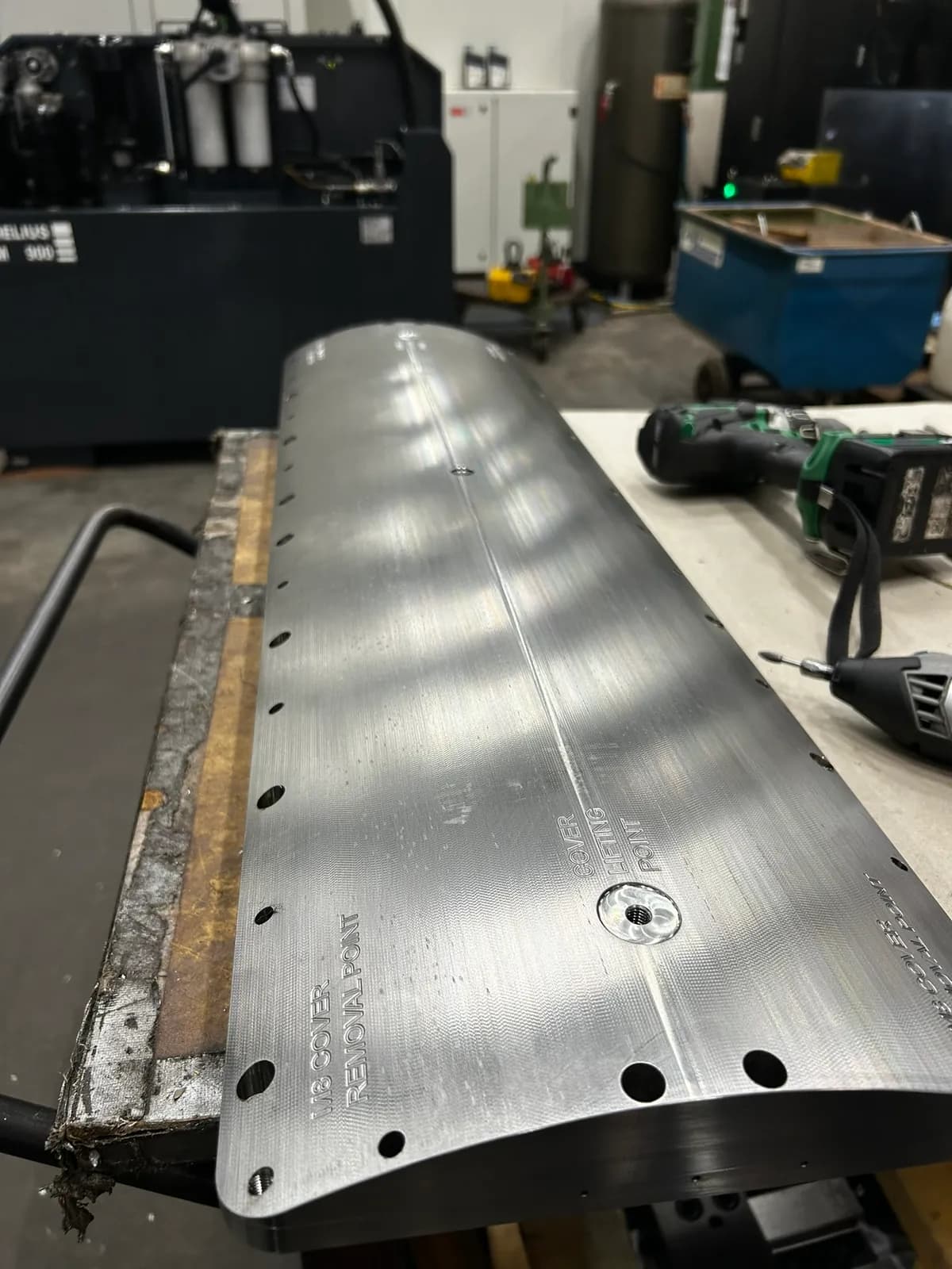 Long cover strip with a curved surface, a series of holes and engraved markings