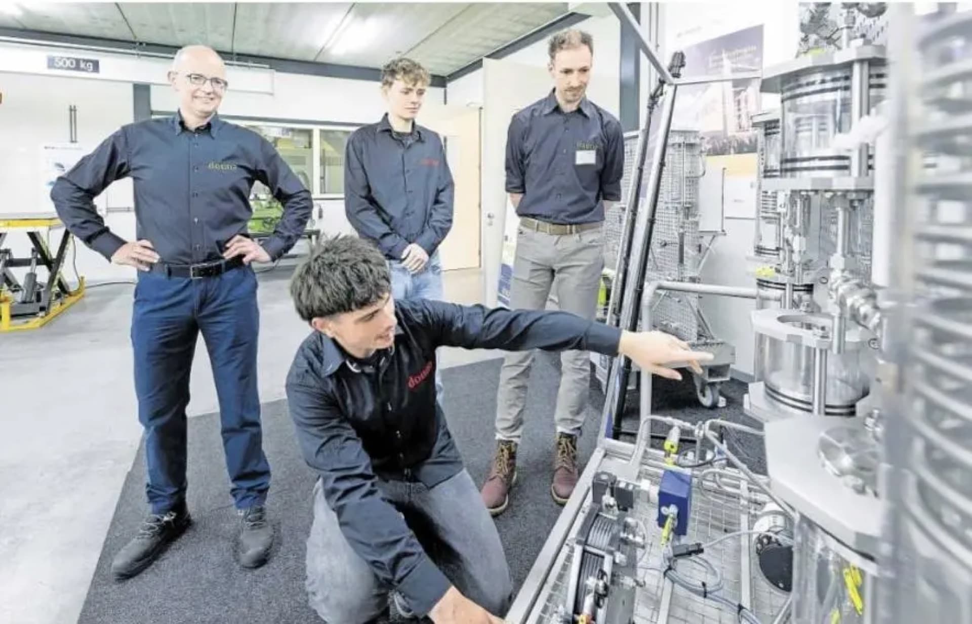 Douna-medewerkers bespreken een technische installatie in de werkplaats